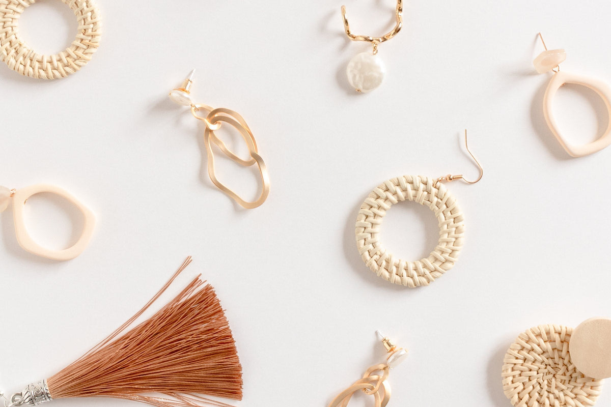 A pattern of hoop and drop earrings on a white background