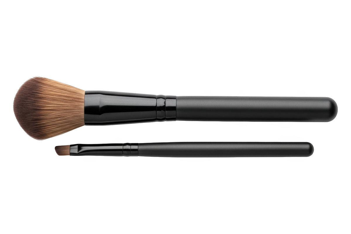 A powder brush and a fine angled brush on a white background