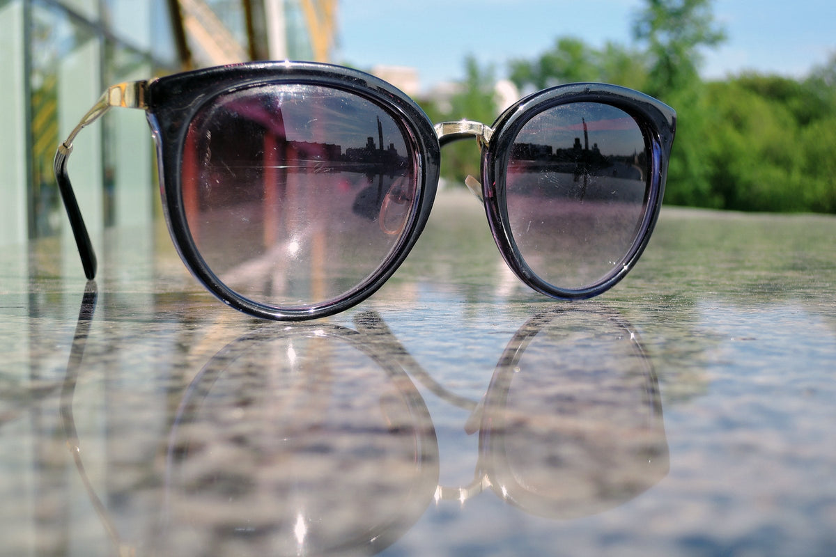 A pair of round sunglasses resting on a marble surface