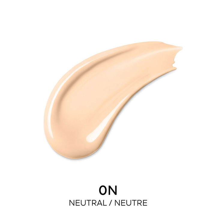 Guerlain Beige and dark brown liquid concealer in transparent cylindrical bottle with metallic cap and wand.