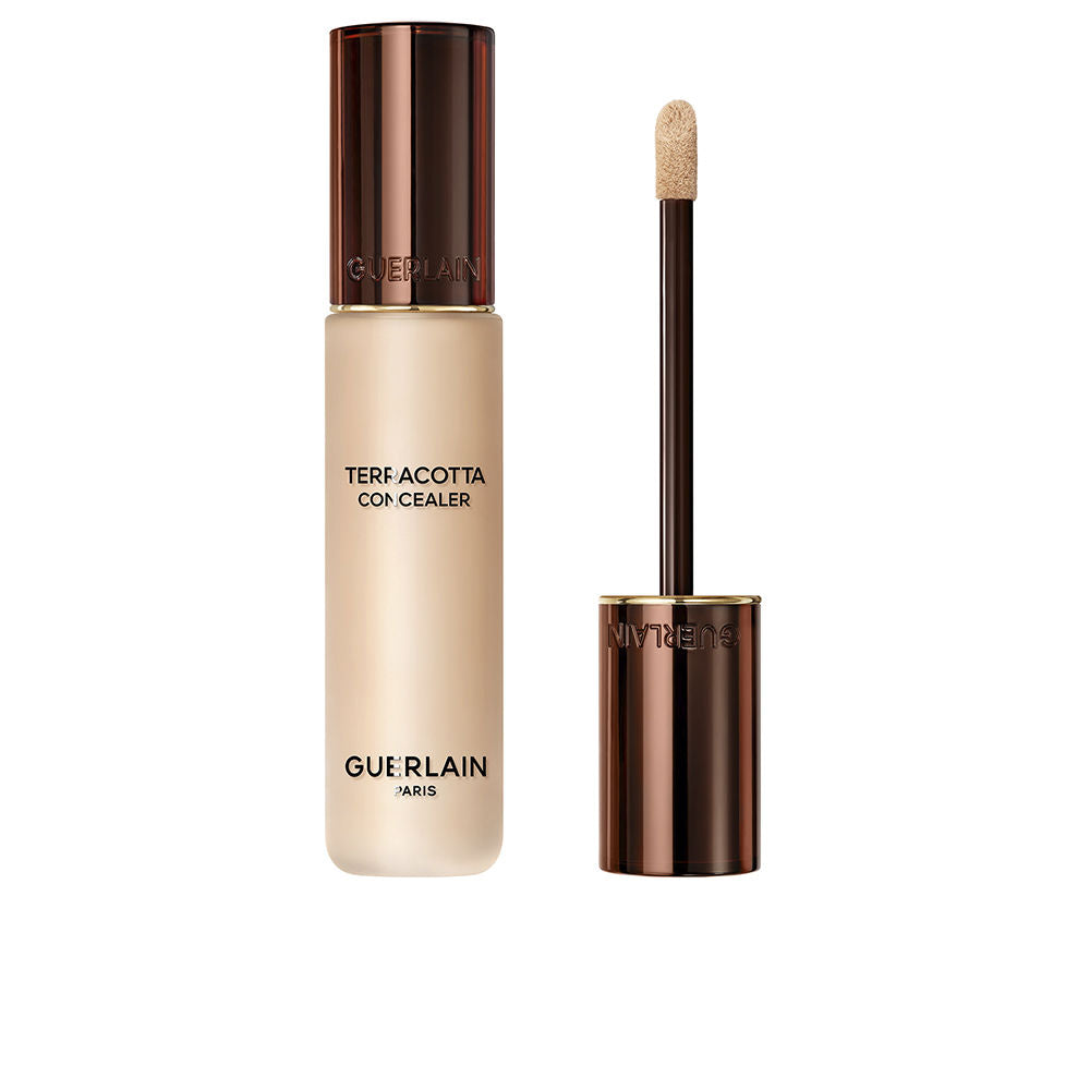 Guerlain Beige and dark brown liquid concealer in transparent cylindrical bottle with metallic cap and wand.
