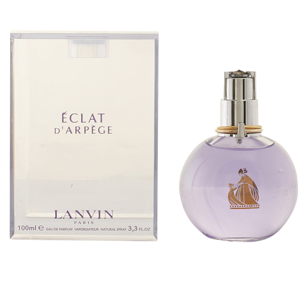 Lanvin Light purple glass round perfume bottle with silver cap, gold rings at neck, transparent box nearby.