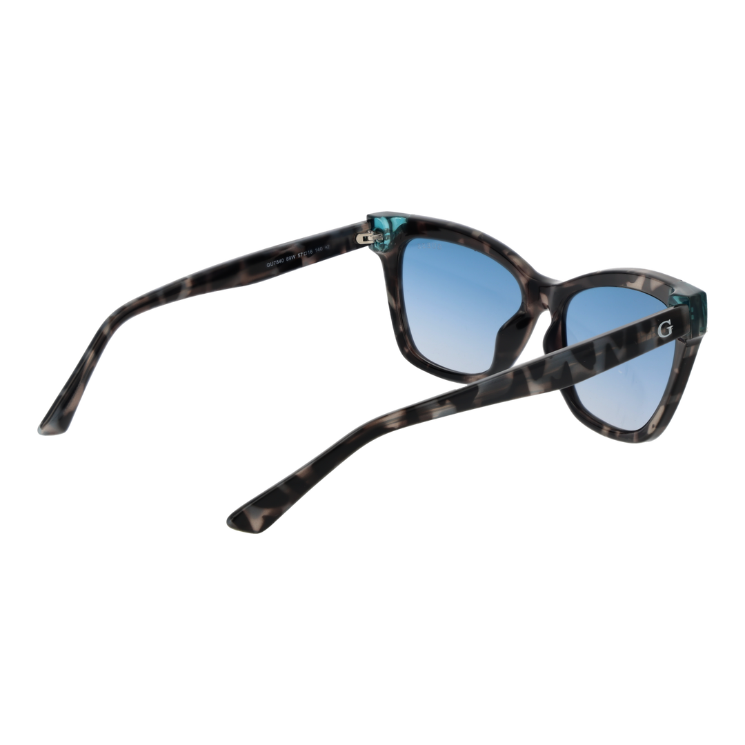 Guess tortoise cat-eye sunglasses with blue gradient lenses and teal corner accents on a neutral background